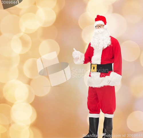 Image of man in costume of santa claus showing thumbs up