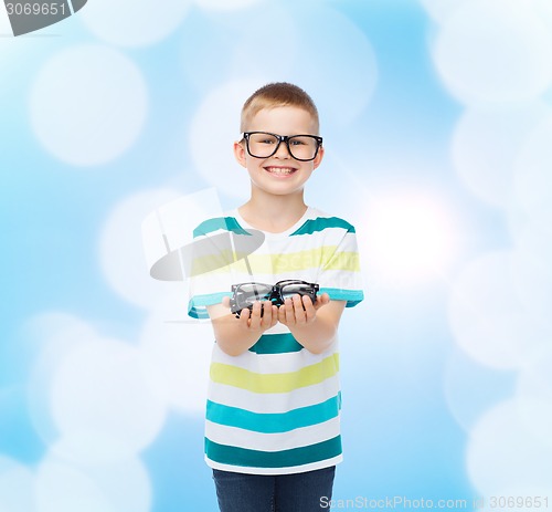 Image of smiling boy in eyeglasses holding spectacles