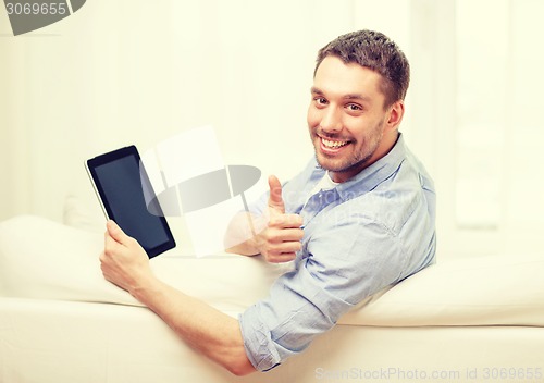 Image of smiling man working with tablet pc at home