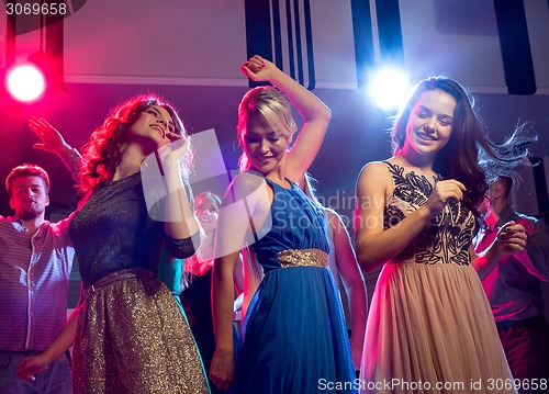 Image of smiling friends dancing in club