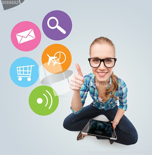 Image of smiling teen girl sitting on floor with tablet pc