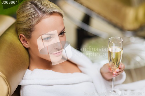 Image of beautiful young woman drinking champagne at spa