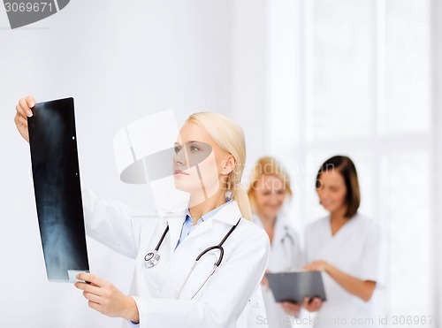 Image of serious female doctor looking at x-ray