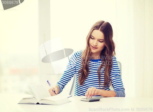 Image of student girl with book, calculator and notebook