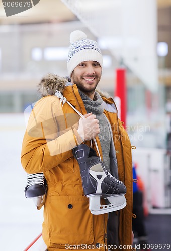 Image of happy young man with ice-skates on skating rink