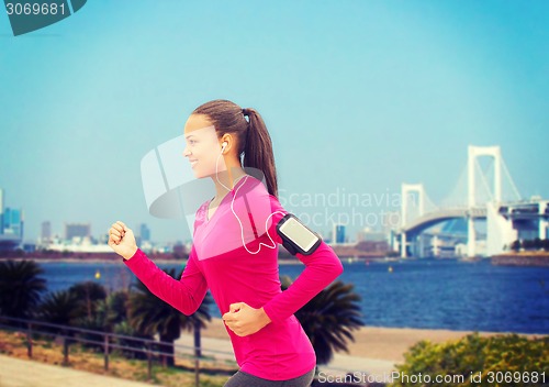 Image of smiling young woman running outdoors