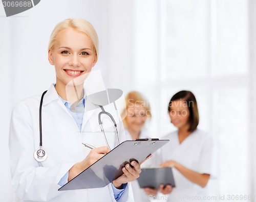 Image of smiling female doctor with clipboard