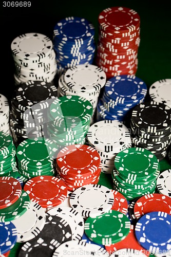 Image of close up of casino chips on green table surface