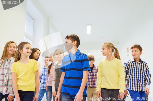 Image of group of smiling school kids walking in corridor