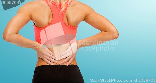 Image of close up of sporty woman touching her back