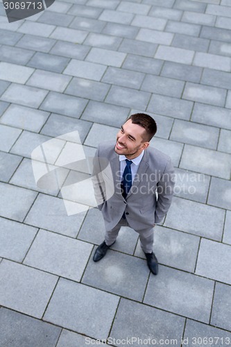Image of young smiling businessman outdoors from top