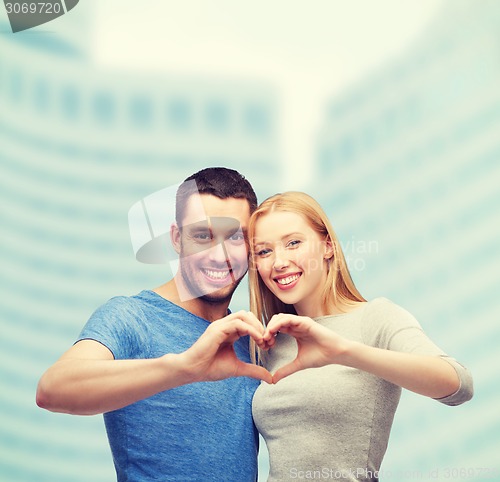 Image of smiling couple showing heart with hands