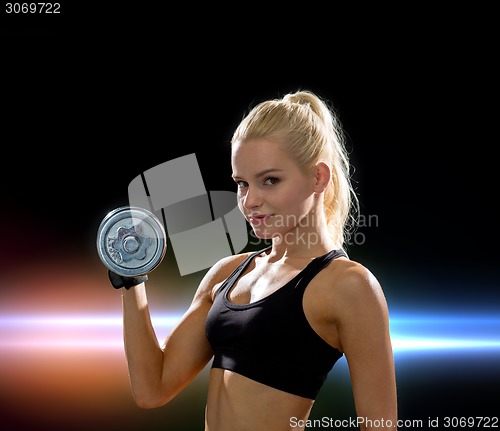 Image of young sporty woman with heavy steel dumbbell