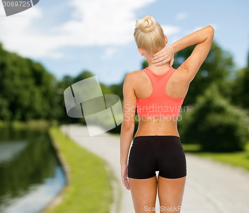 Image of sporty woman touching her neck