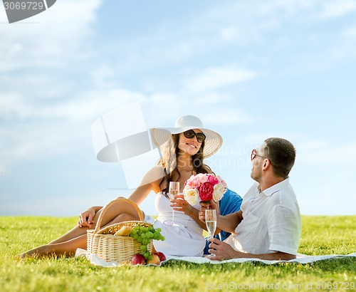 Image of smiling couple drinking champagne on picnic