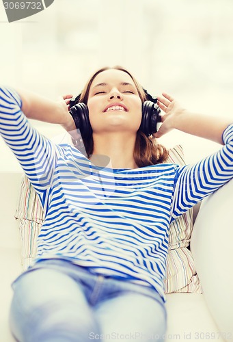 Image of smiling young girl in headphones at home