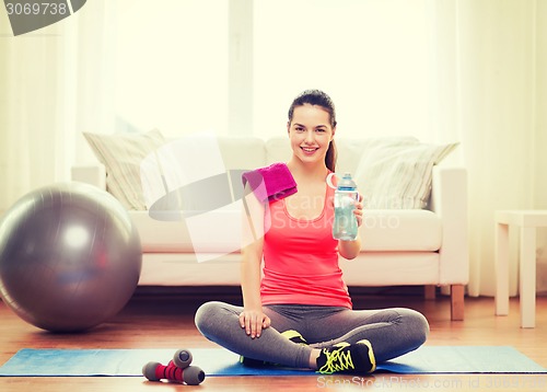 Image of smiling girl with bottle of water after exercising