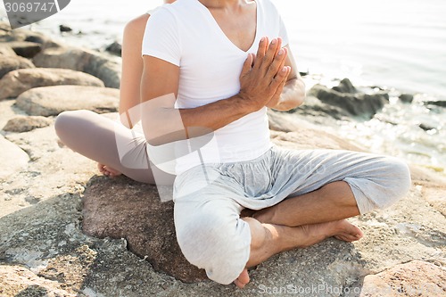 Image of close up of couple making yoga exercises outdoors