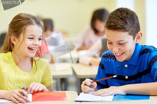 Image of group of school kids writing test in classroom