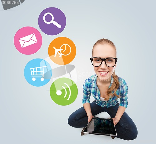 Image of smiling teen girl sitting on floor with tablet pc