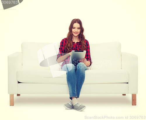 Image of teenage girl sitting on sofa with tablet pc