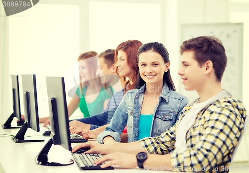 Image of smiling student with computer studying at school