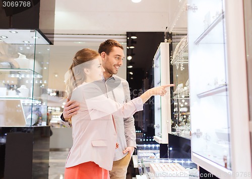 Image of couple looking to shopping window at jewelry store