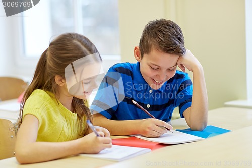 Image of group of school kids writing test in classroom