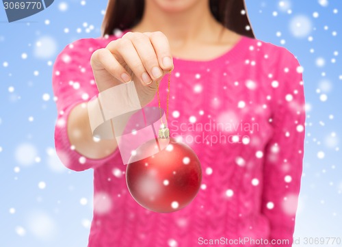 Image of close up of woman in sweater with christmas ball