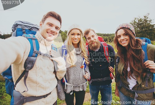 Image of group of smiling friends with backpacks hiking