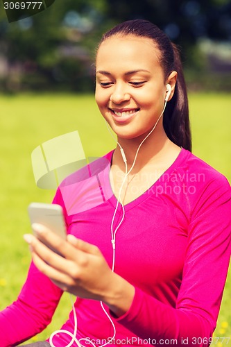 Image of smiling african american woman with smartphone