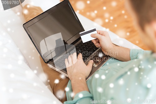 Image of close up of man with laptop and credit card