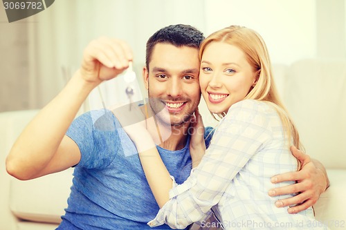 Image of smiling couple holding keys at home