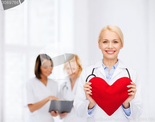 Image of smiling female doctor with heart and stethoscope