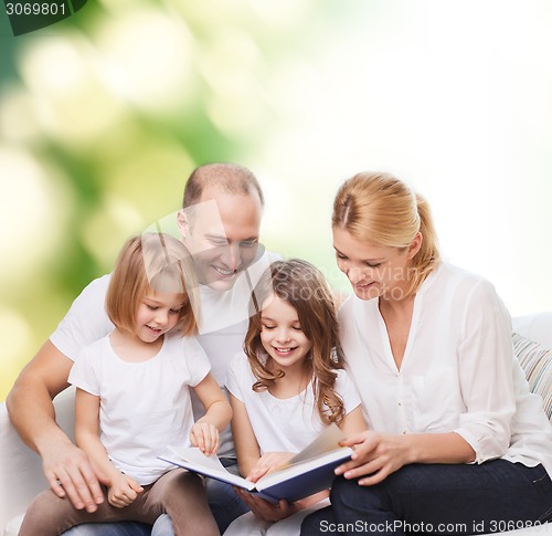 Image of happy family with book at home