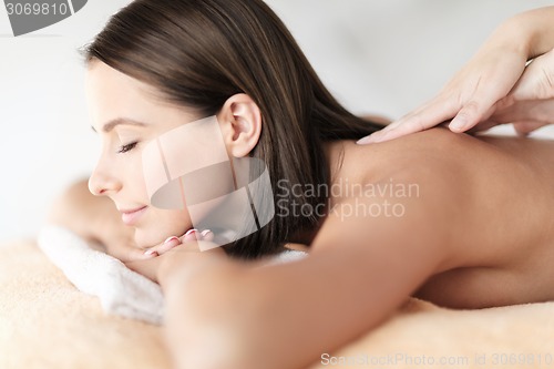 Image of beautiful woman in spa salon getting massage