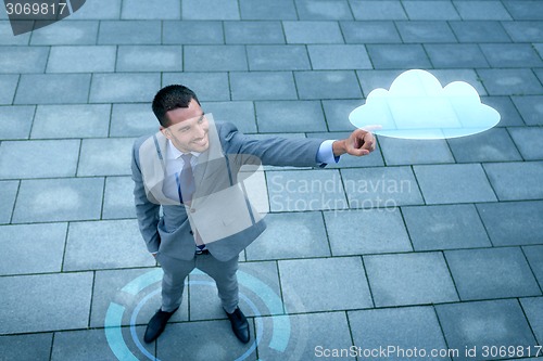 Image of smiling businessman with cloud projection outdoors