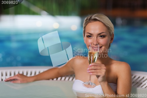 Image of happy woman drinking champagne at swimming pool