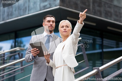 Image of serious businessmen with tablet pc outdoors