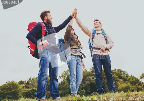 Image of group of smiling friends with backpacks hiking