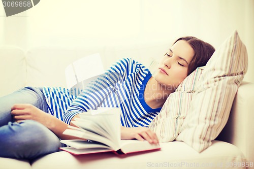 Image of smiling teenage girl sleeping on sofa at home