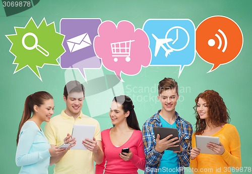 Image of happy friends with smartphones and tablet pc