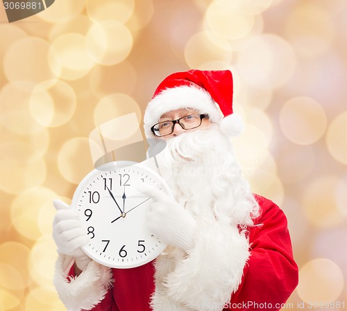 Image of man in costume of santa claus with clock