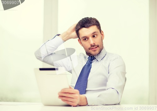 Image of stressed businessman with tablet pc and documents