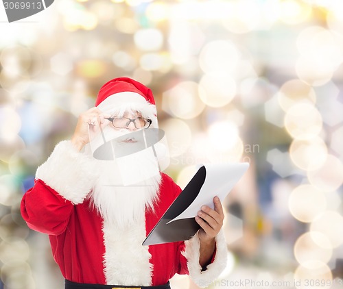 Image of man in costume of santa claus with notepad