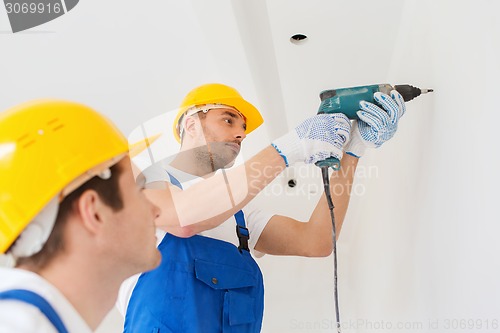 Image of group of builders with drill indoors