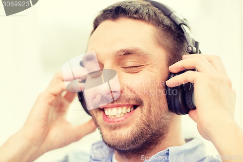 Image of smiling young man in headphones at home