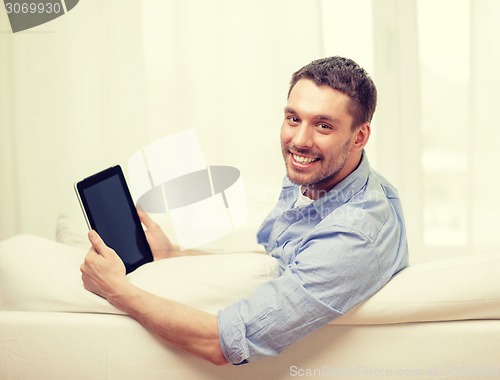 Image of smiling man working with tablet pc at home