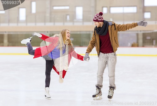 Image of happy couple holding hands on skating rink