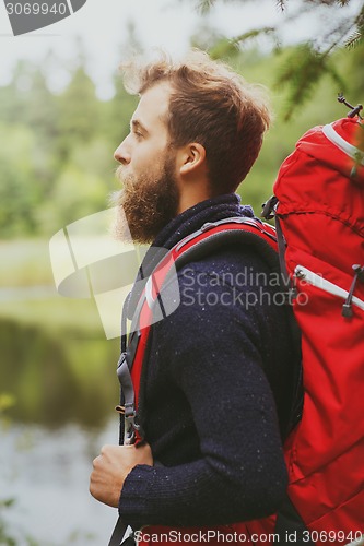 Image of smiling man with beard and backpack hiking